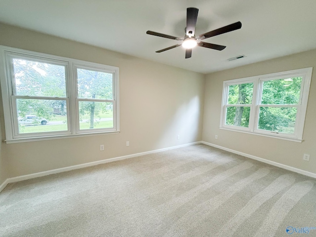 spare room with plenty of natural light, baseboards, a ceiling fan, and carpet