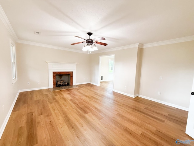 unfurnished living room featuring a ceiling fan, light wood finished floors, a brick fireplace, ornamental molding, and baseboards