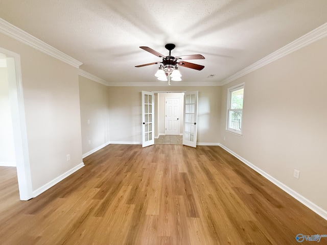 spare room featuring ceiling fan, wood finished floors, baseboards, ornamental molding, and french doors
