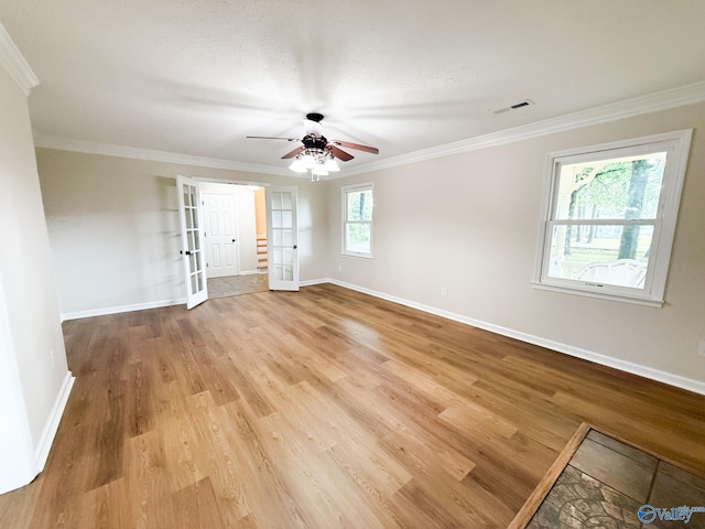 spare room with light wood finished floors, baseboards, ornamental molding, a ceiling fan, and french doors