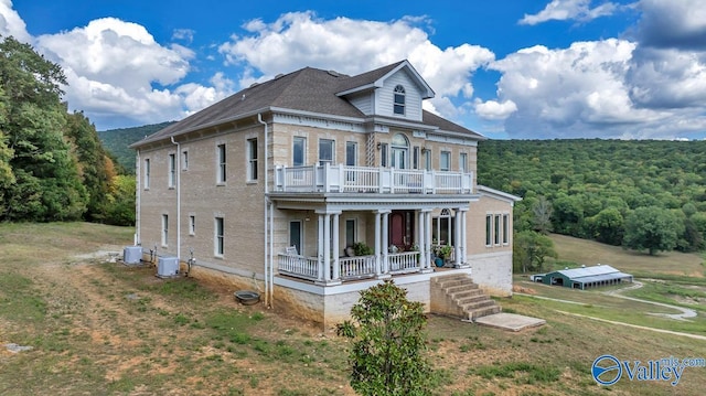 view of front facade featuring a balcony, covered porch, and central AC