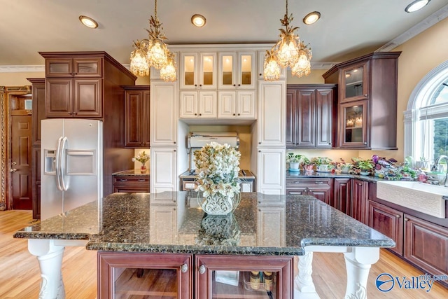 kitchen featuring hanging light fixtures, ornamental molding, sink, a large island, and stainless steel fridge with ice dispenser