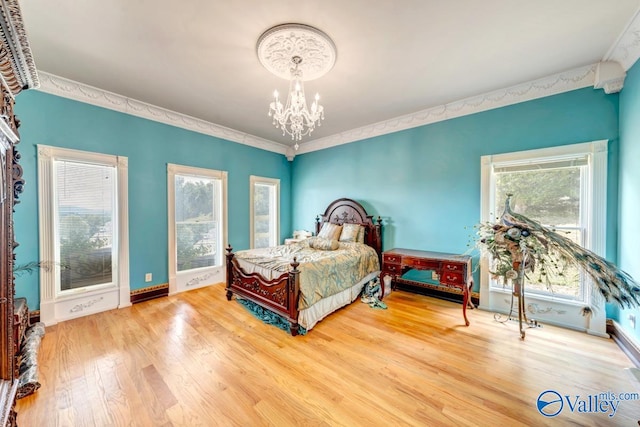 bedroom with ornamental molding, an inviting chandelier, and hardwood / wood-style flooring