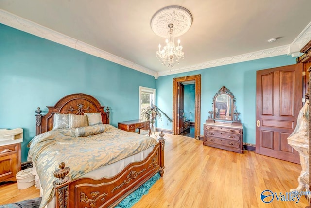 bedroom featuring an inviting chandelier and light hardwood / wood-style floors