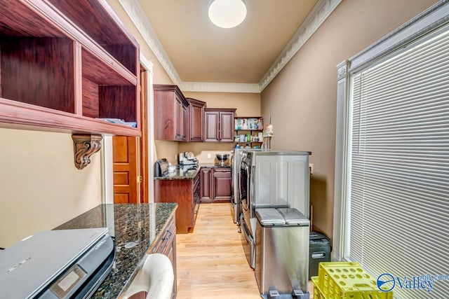 kitchen featuring light hardwood / wood-style flooring, ornamental molding, and dark stone counters