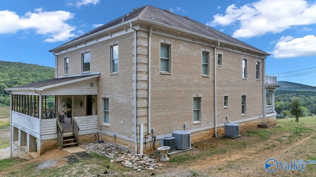 view of side of home featuring a mountain view and central AC