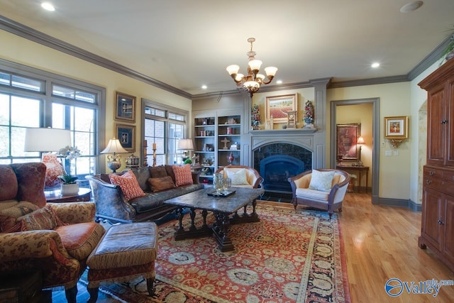 living room featuring ornamental molding, light wood-type flooring, and a notable chandelier