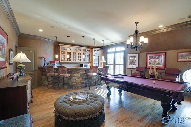 playroom featuring pool table, a chandelier, bar area, light wood-type flooring, and crown molding