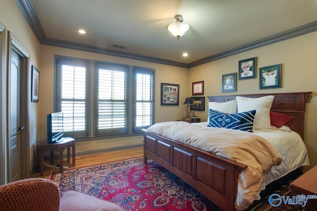 bedroom featuring light hardwood / wood-style flooring and crown molding