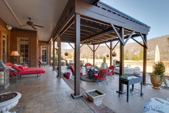 view of patio / terrace featuring ceiling fan and a mountain view