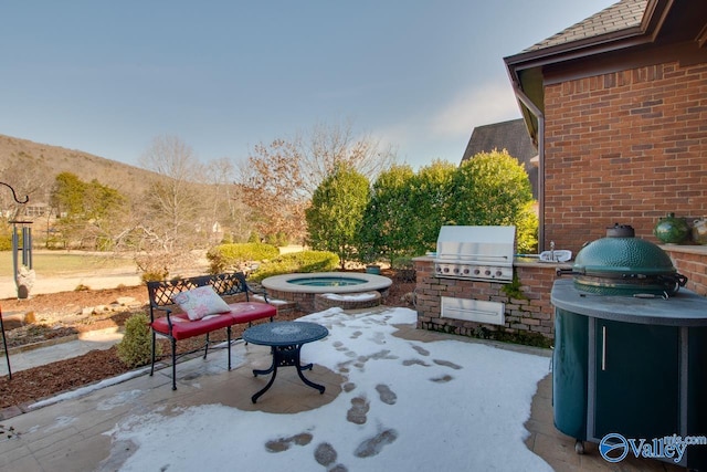 view of patio featuring a mountain view, area for grilling, an in ground hot tub, and grilling area