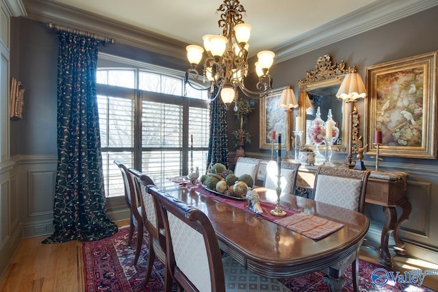 dining space featuring hardwood / wood-style floors, an inviting chandelier, and crown molding