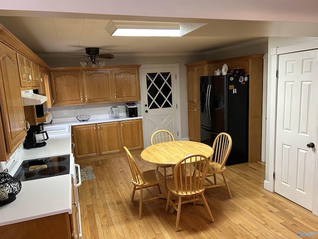 kitchen with brown cabinets, white electric stove, light wood finished floors, and black fridge