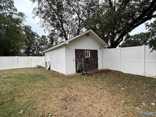 view of outdoor structure featuring a fenced backyard and an outbuilding