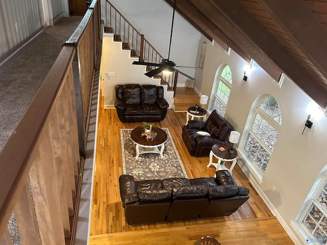 living room featuring high vaulted ceiling, wood-type flooring, beam ceiling, and ceiling fan