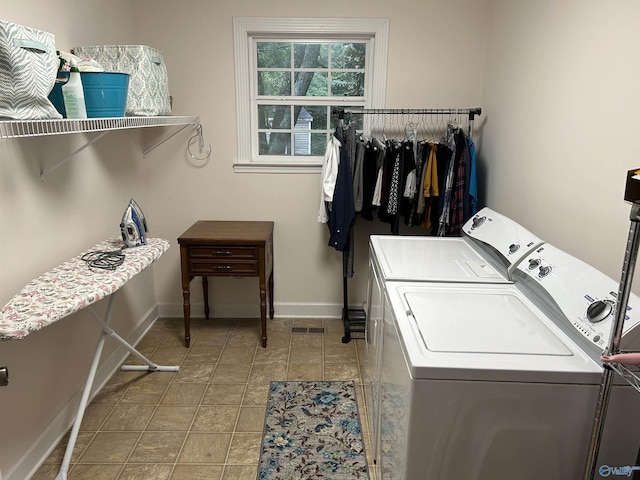 washroom featuring laundry area, washer and clothes dryer, and baseboards