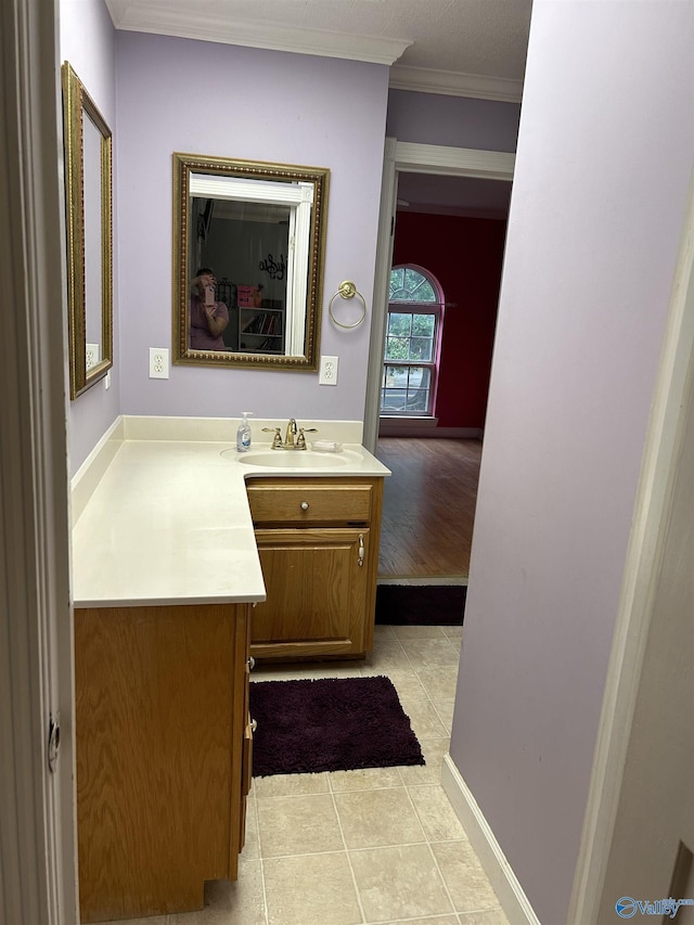 bathroom with tile patterned floors, crown molding, and vanity