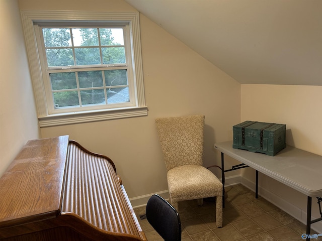 living area featuring baseboards and vaulted ceiling