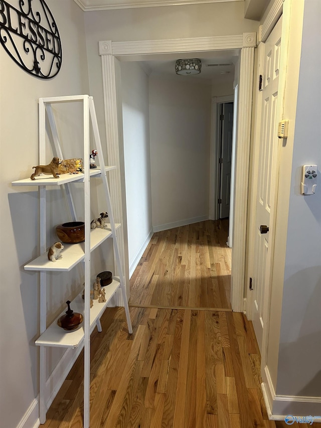 corridor with baseboards and wood finished floors