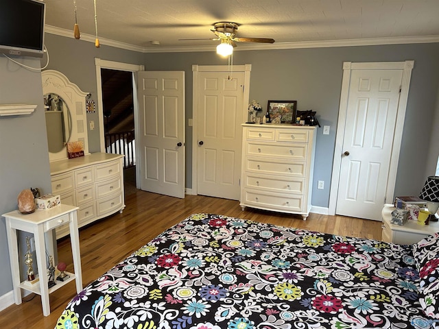 bedroom with wood finished floors and crown molding