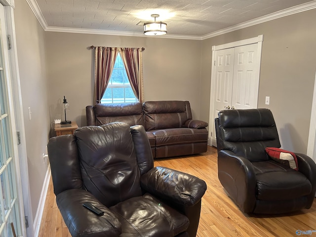 living area featuring light wood-style floors, ornamental molding, and baseboards