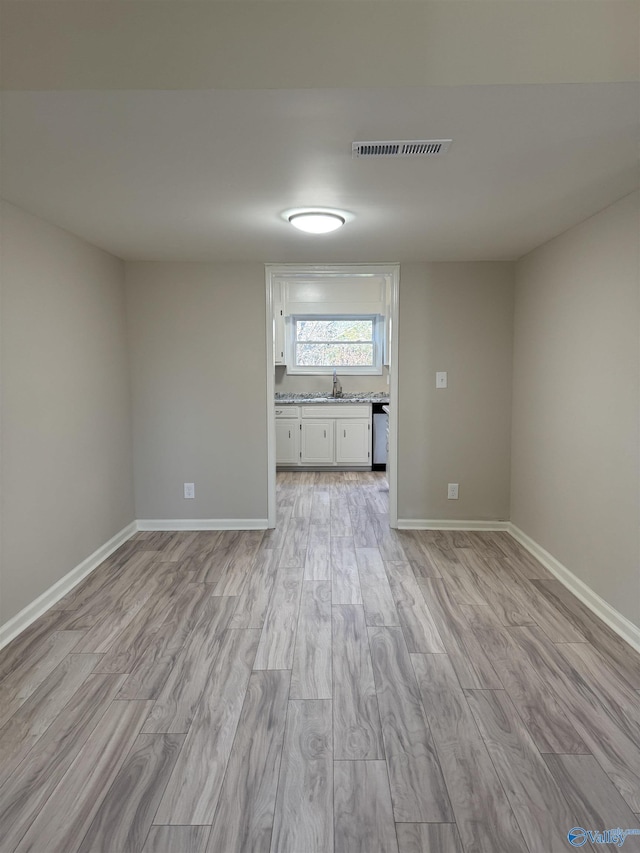 empty room featuring sink and light wood-type flooring