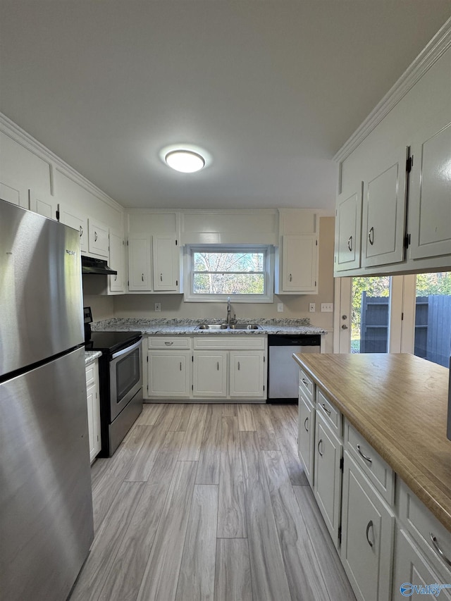 kitchen with stainless steel appliances, light hardwood / wood-style flooring, sink, white cabinets, and crown molding