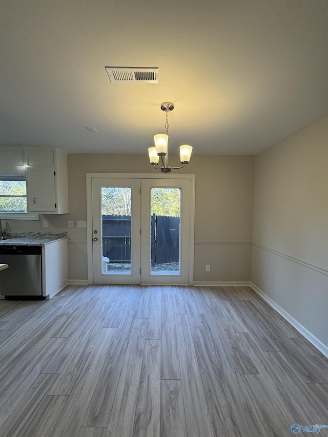 interior space with an inviting chandelier and light hardwood / wood-style floors