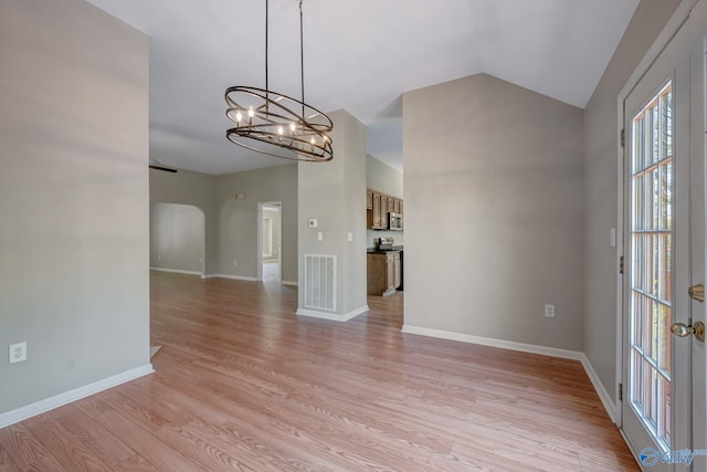 interior space featuring an inviting chandelier, vaulted ceiling, visible vents, light wood finished floors, and baseboards