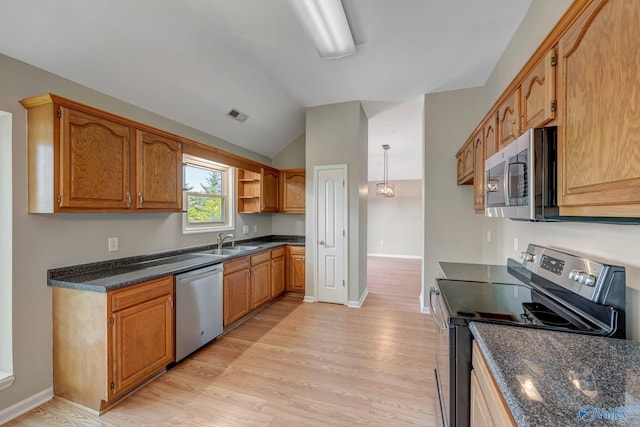 kitchen with light wood-style flooring, appliances with stainless steel finishes, a sink, and lofted ceiling