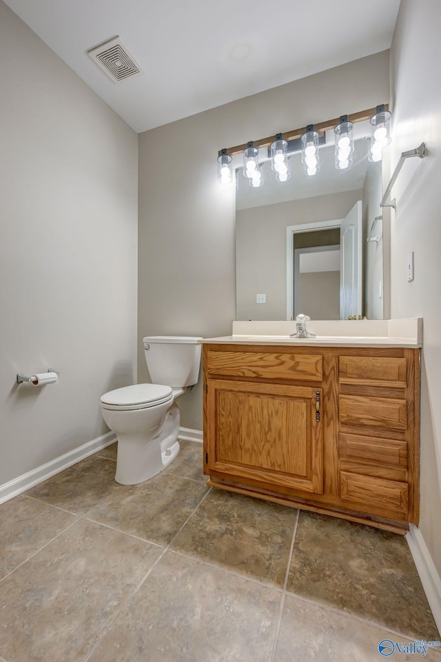 bathroom with visible vents, toilet, vanity, and baseboards