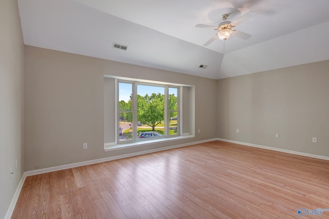 spare room with light wood finished floors, visible vents, and ceiling fan