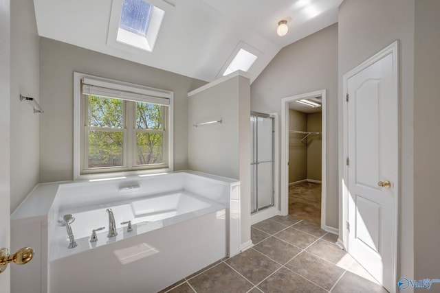 full bathroom with a bath, a spacious closet, a shower stall, lofted ceiling with skylight, and tile patterned flooring
