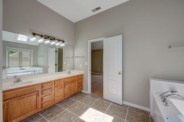 bathroom with a bath, a sink, visible vents, and tile patterned floors