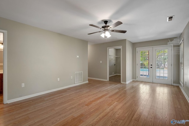 unfurnished room featuring light wood-style floors, french doors, a ceiling fan, and visible vents