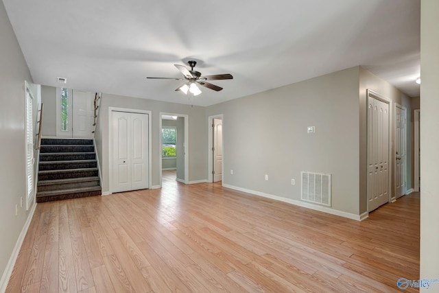 unfurnished living room featuring light wood-style flooring, baseboards, a ceiling fan, and visible vents