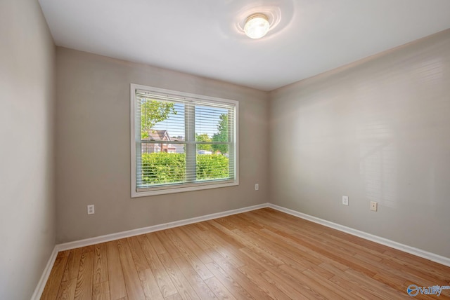 spare room with light wood-style flooring and baseboards