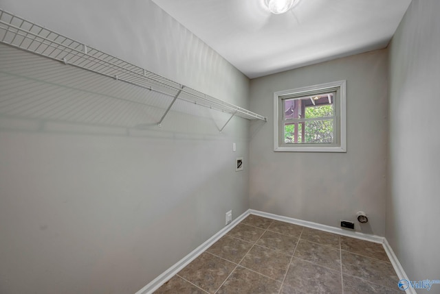 washroom with baseboards, dark tile patterned floors, hookup for a washing machine, and laundry area