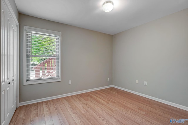 empty room featuring baseboards and light wood-type flooring