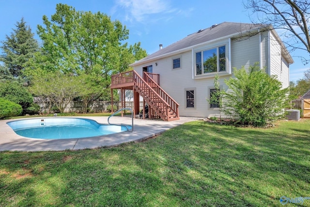 back of house featuring a lawn, fence, stairway, a wooden deck, and a fenced in pool