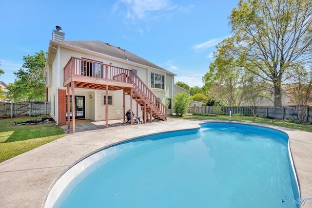 back of house featuring a wooden deck, a fenced backyard, stairway, a chimney, and a fenced in pool