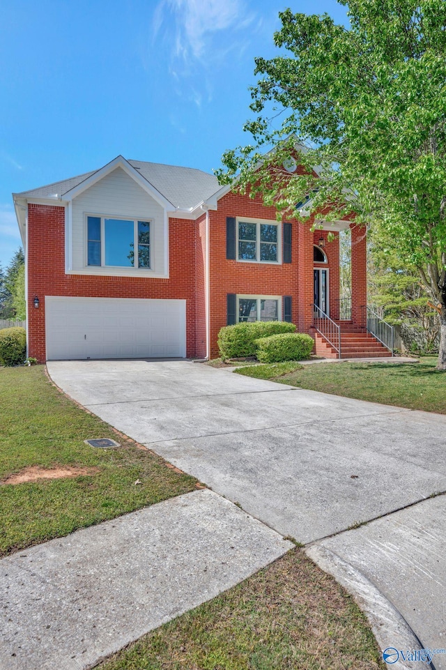 split foyer home with concrete driveway, brick siding, a garage, and a front lawn