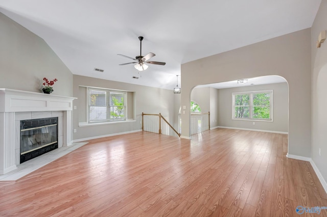 unfurnished living room with light wood-type flooring, visible vents, ceiling fan, and a healthy amount of sunlight