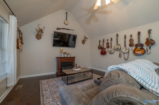 living room with ceiling fan, dark wood-type flooring, and lofted ceiling