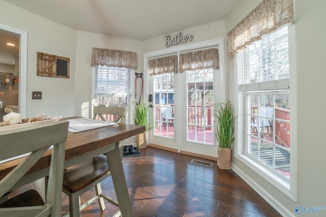 dining space featuring a textured ceiling and dark wood-type flooring