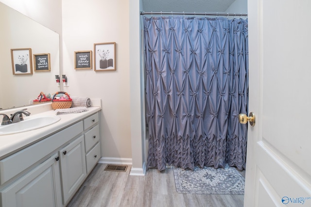 bathroom featuring hardwood / wood-style floors, vanity, and walk in shower