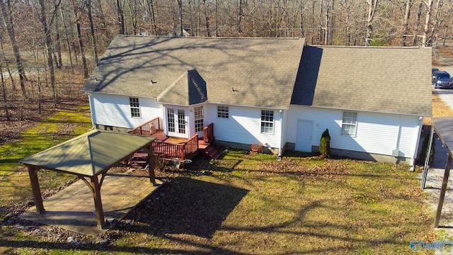 back of house with a carport, a yard, and a wooden deck