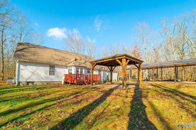 rear view of house featuring a gazebo, a yard, and a deck