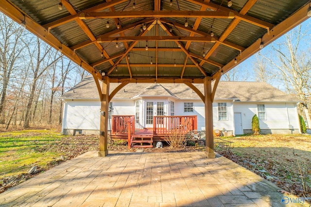 wooden terrace with a gazebo and a patio