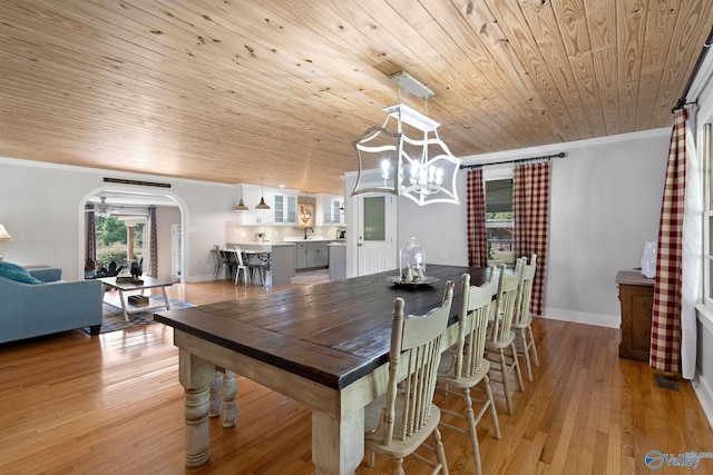 dining space with wooden ceiling, arched walkways, ornamental molding, and plenty of natural light